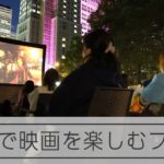 野外の公園で映画鑑賞　新宿ビル群を背景に